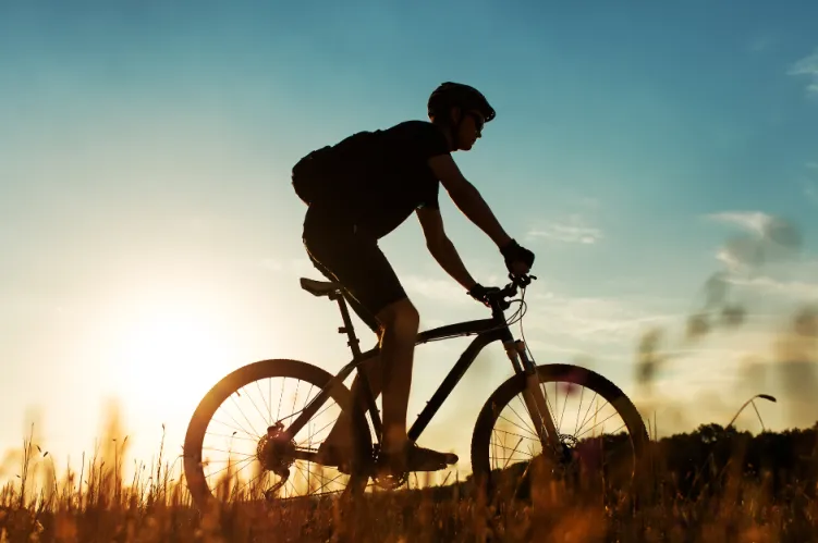 rowerzysta na tle zachodzącego słońca 