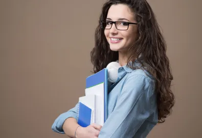 uśmiechnięta kobieta trzymająca podręczniki w ręku